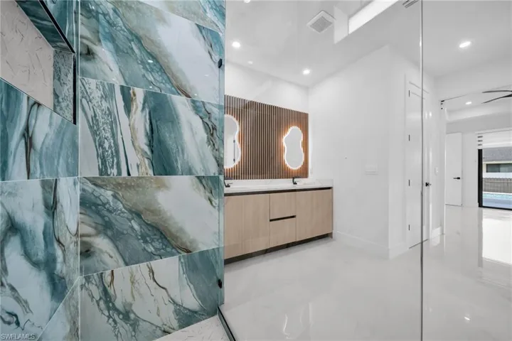 Full bathroom featuring double vanity, recessed lighting, and finished concrete floors
