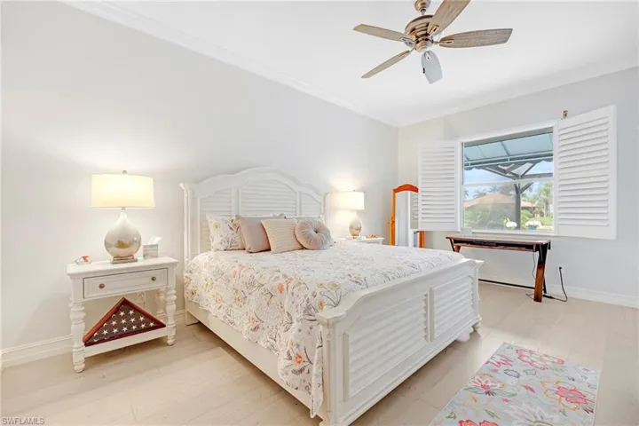 Bedroom featuring ceiling fan, light hardwood / wood-style floors, and crown molding