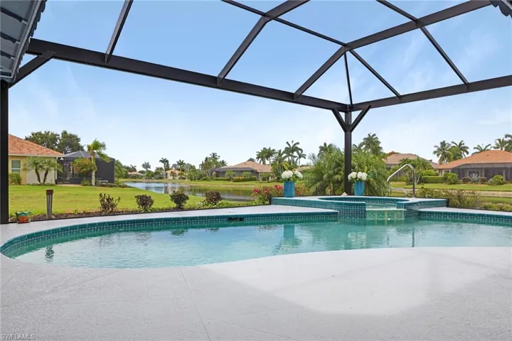 View of swimming pool featuring a lanai, an in ground hot tub, and a yard