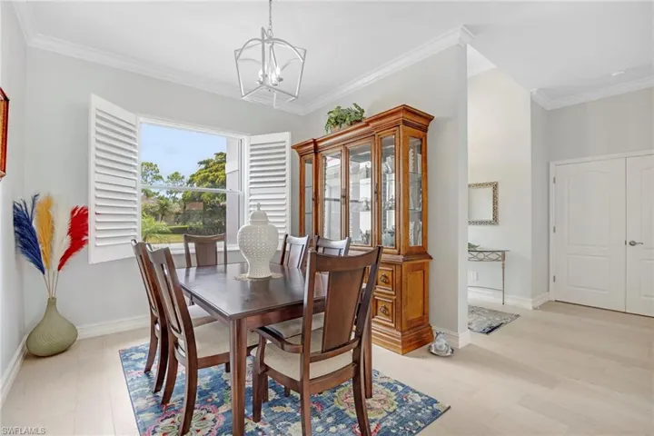 Dining room featuring a notable chandelier, light hardwood / wood-style flooring, and crown molding