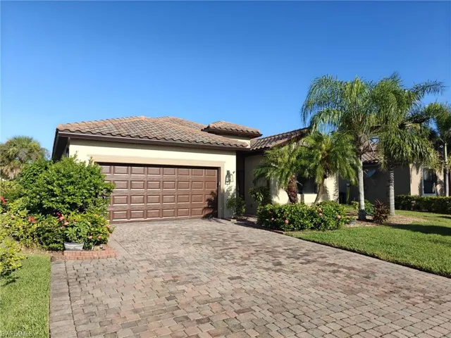 Mediterranean / spanish house with stucco siding, decorative driveway, a garage, and a front yard