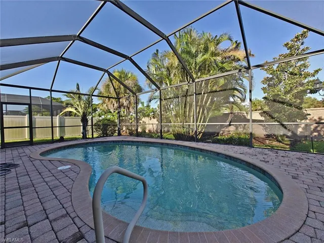Outdoor pool featuring a sunroom and a lanai