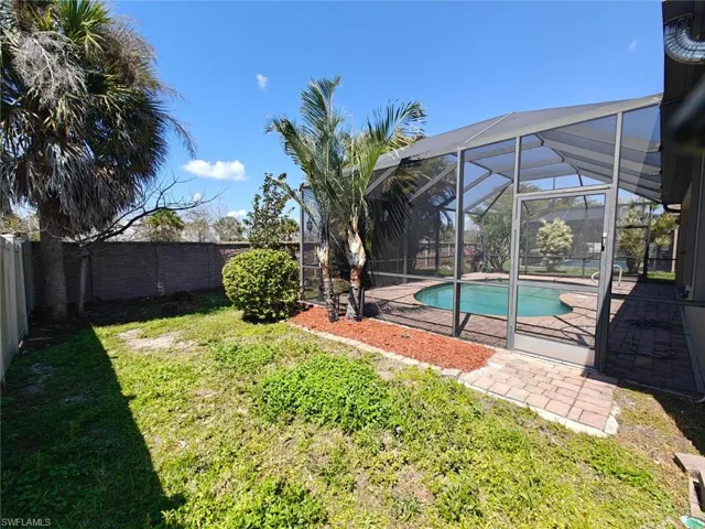 Fenced backyard featuring a lanai, a patio, an outdoor pool, and a sunroom