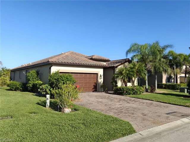 Mediterranean / spanish-style home with stucco siding, a front yard, an attached garage, decorative driveway, and a tile roof