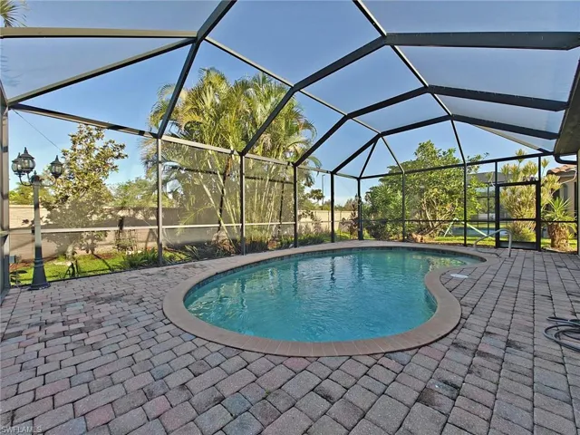 Outdoor pool featuring a lanai, a sunroom, and a patio