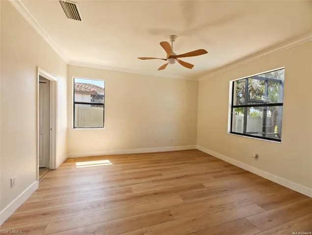 Unfurnished bedroom with light wood-type flooring, ornamental molding, and ceiling fan