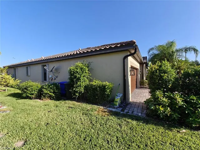 View of property exterior with stucco siding and a yard
