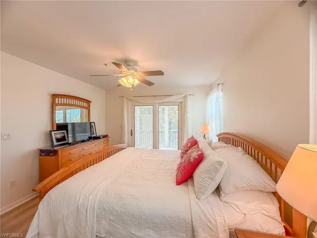 Bedroom featuring access to exterior, baseboards, and a ceiling fan