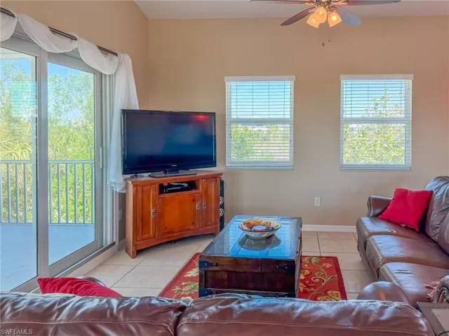 Living area featuring plenty of natural light, a ceiling fan, and light tile patterned flooring