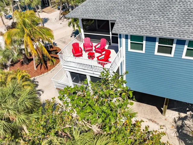 View of side of property featuring a shingled roof and stairway