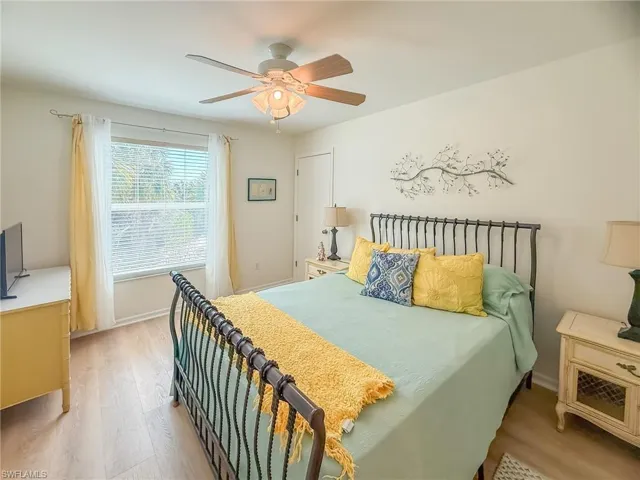 Bedroom with ceiling fan, wood finished floors, and baseboards