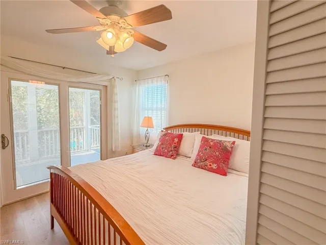 Bedroom with access to outside, ceiling fan, and wood finished floors