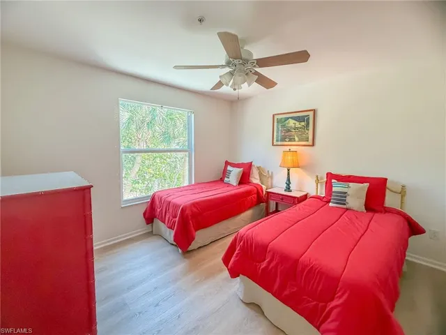Bedroom with ceiling fan, baseboards, and wood finished floors