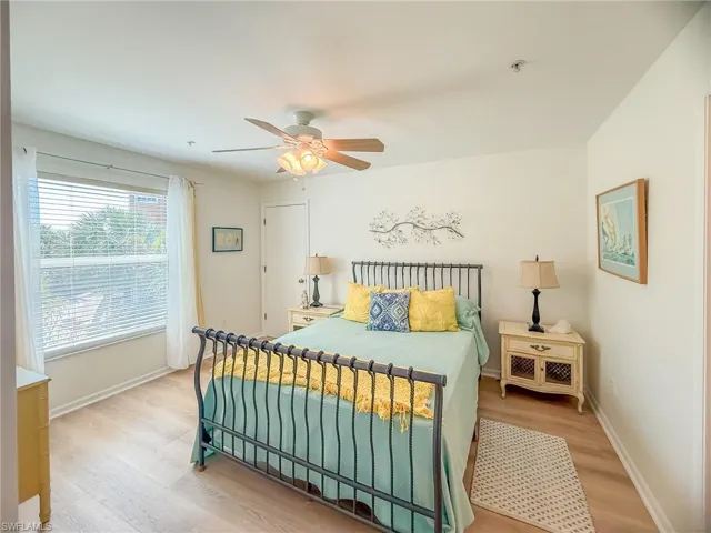 Bedroom featuring light wood finished floors, ceiling fan, and baseboards