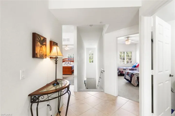 Corridor featuring light colored carpet