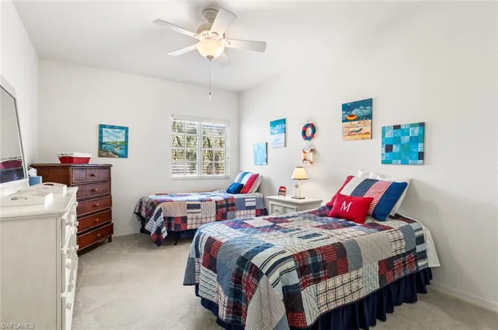 Carpeted bedroom featuring ceiling fan