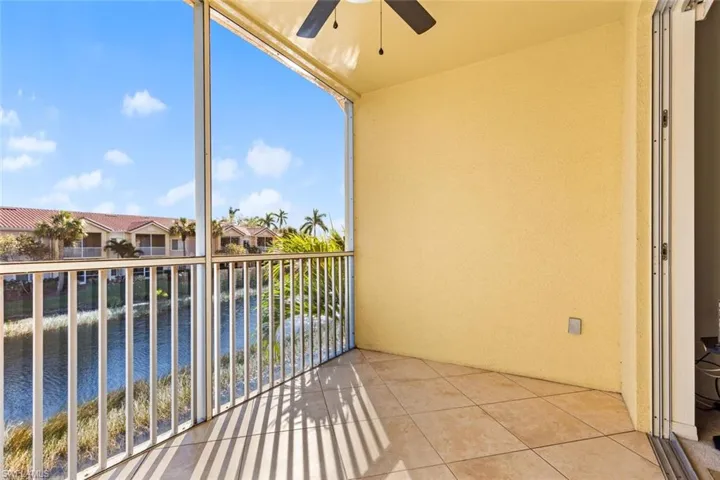 Balcony with a water view and ceiling fan