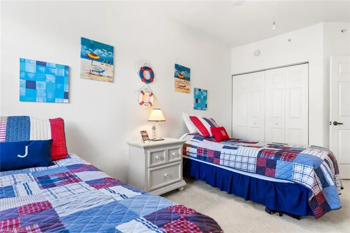 Carpeted bedroom with ceiling fan and a closet