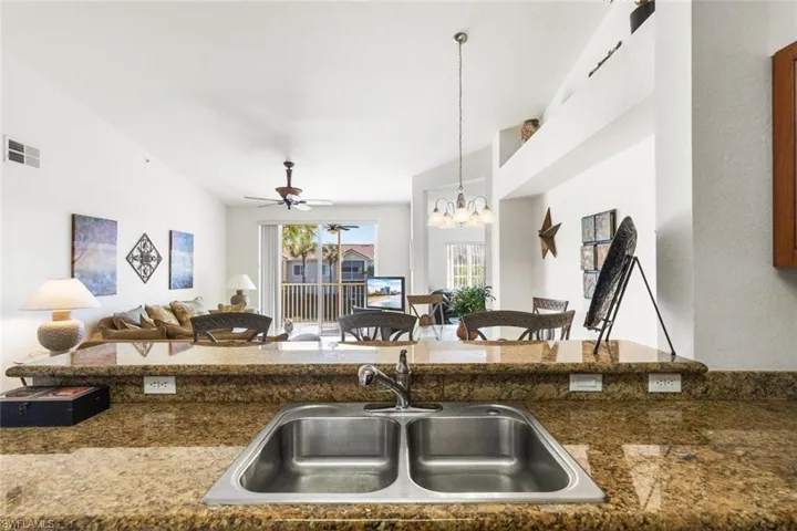 Kitchen featuring ceiling fan with notable chandelier, sink, and hanging light fixtures