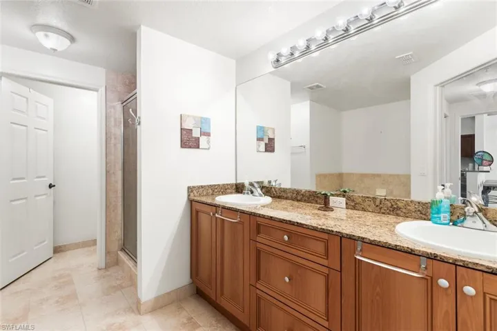 Bathroom with vanity, tile patterned floors, and walk in shower