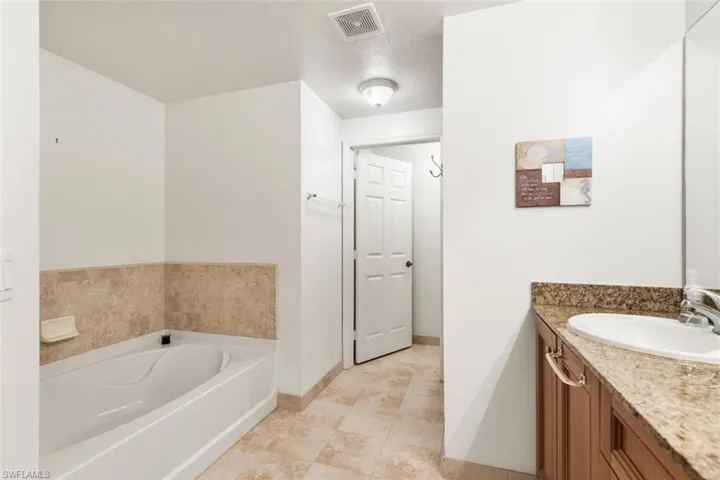 Bathroom featuring vanity, a bathtub, and a textured ceiling