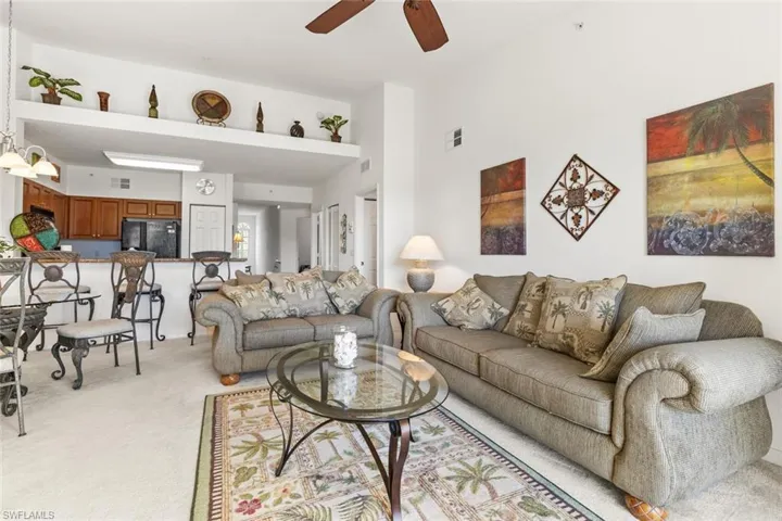 Living room with ceiling fan and light carpet