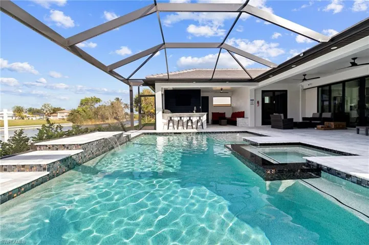 View of pool with a patio, a pool with connected hot tub, outdoor lounge area, a sunroom, and ceiling fan