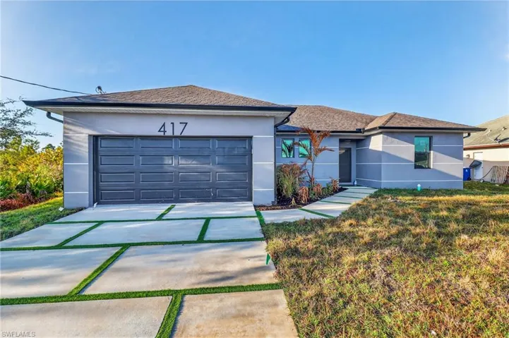 Single story home featuring stucco siding, driveway, and an attached garage