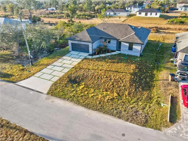 View of front of home with driveway, a garage, a front lawn, and a residential view