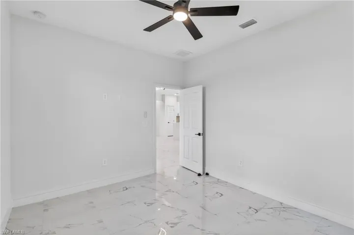 Spare room featuring a ceiling fan and light marble finish flooring