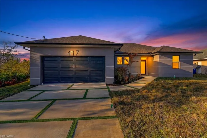 View of front of home featuring driveway, stucco siding, a garage, and roof with shingles