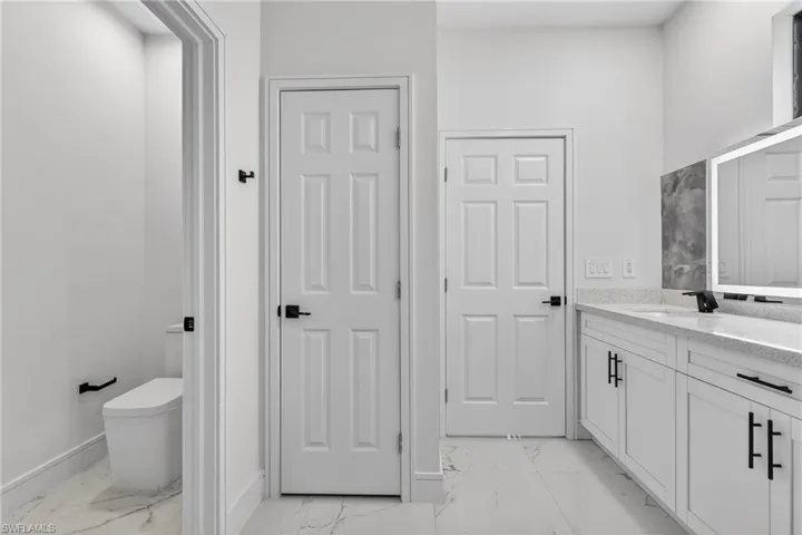 Full bathroom with vanity and light marble finish flooring