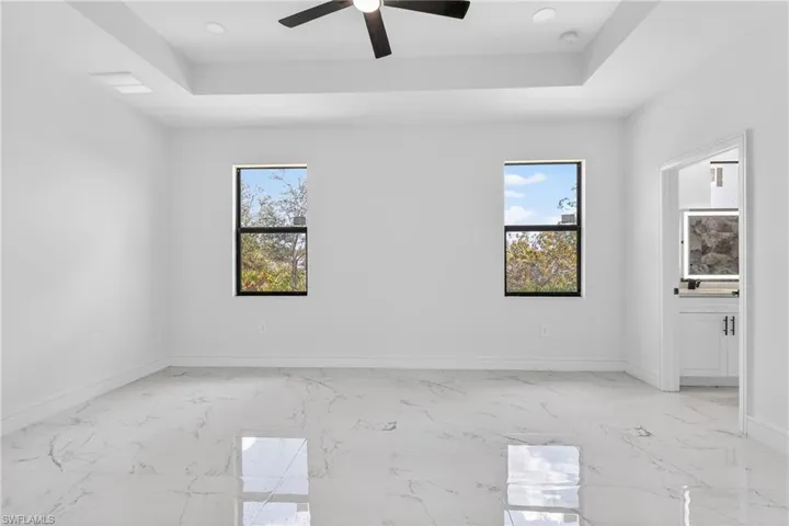 Spare room featuring light marble finish floors, a ceiling fan, and recessed lighting