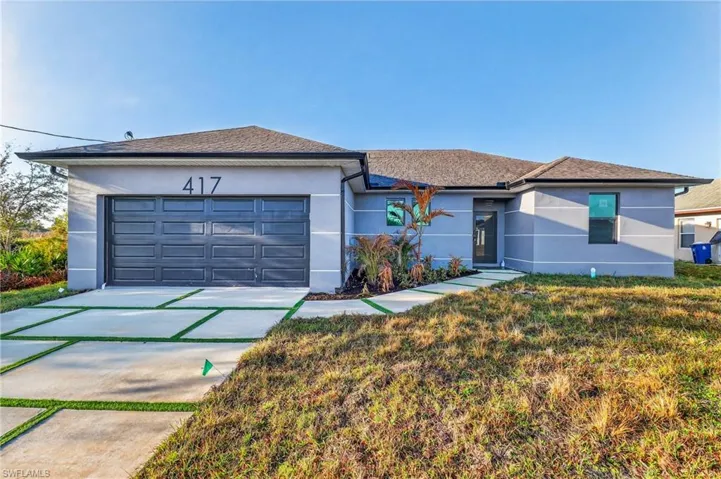 Ranch-style home featuring stucco siding, concrete driveway, an attached garage, a front lawn, and a shingled roof