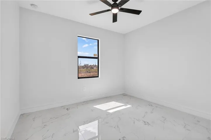 Empty room with light marble finish flooring and ceiling fan