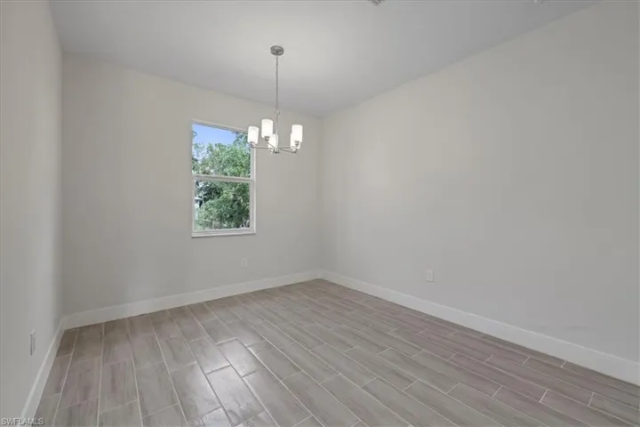 Empty room featuring a chandelier and wood tiled floors