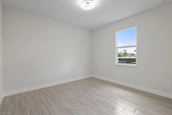 Spare room with baseboards and wood finish floors
