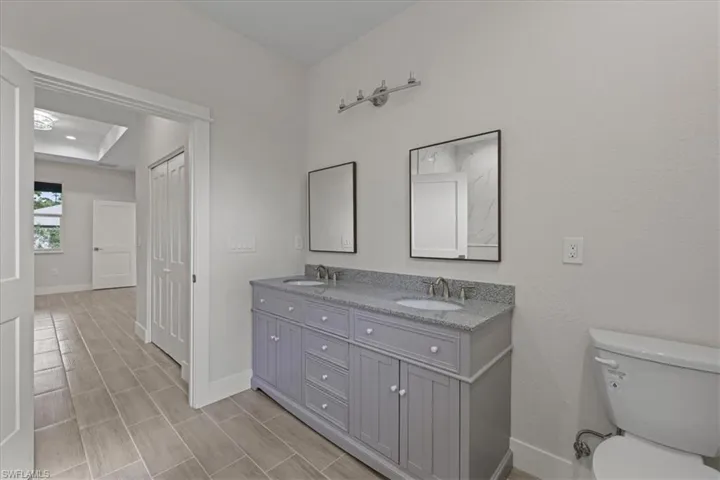 Full bath with double vanity and wood finish floors