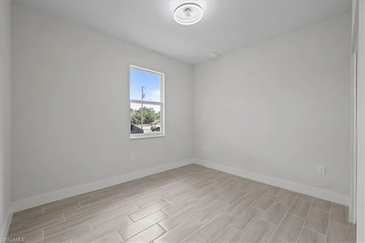 Empty room featuring baseboards and wood finish floors