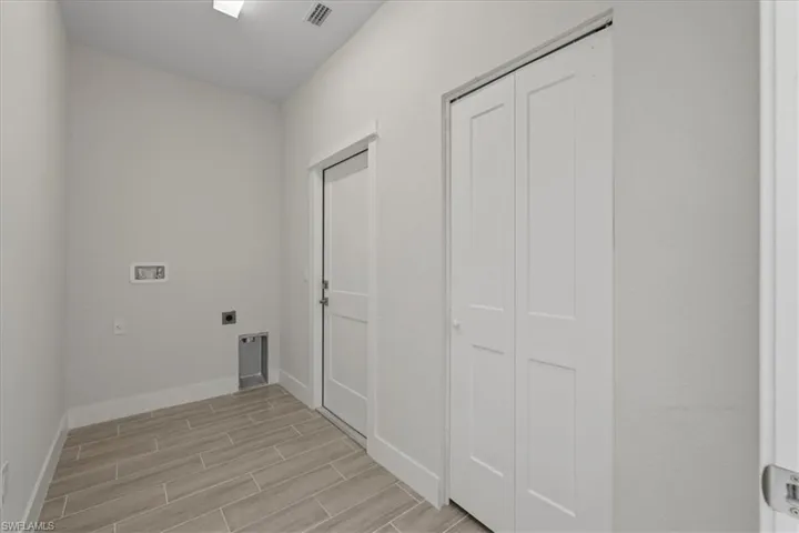 Washroom with wood finish floors, washer hookup, and electric dryer hookup