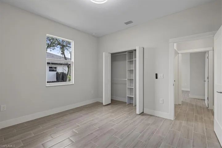 Unfurnished bedroom featuring wood finish floors and a closet