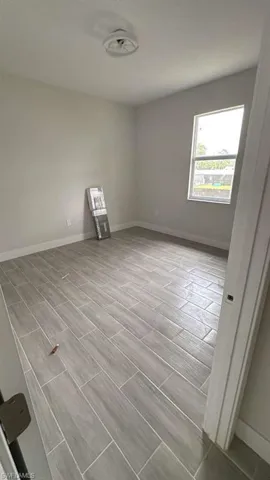 Spare room with baseboards and wood finish floors
