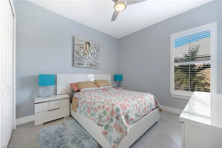 Bedroom featuring a closet, ceiling fan, and light tile patterned floors