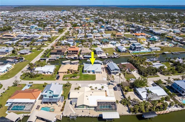 Aerial view of property and surrounding area featuring nearby suburban area and a large body of water