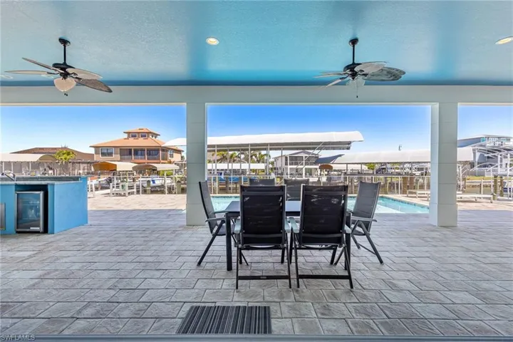 View of patio with a ceiling fan, a community pool, and wine cooler