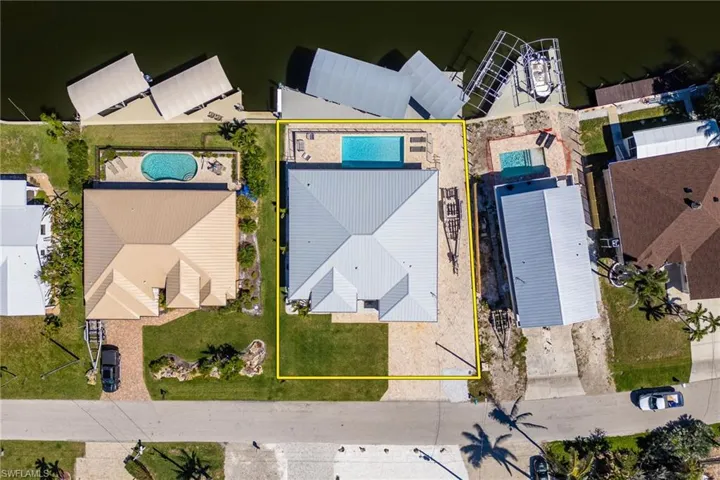 Aerial perspective of suburban area featuring property parcel outlined and a pool