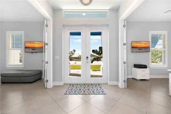 Entryway with french doors, plenty of natural light, and light tile patterned floors