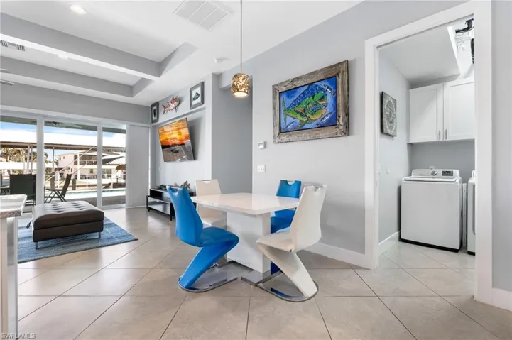 Dining area with light tile patterned floors, washer and dryer, a raised ceiling, and recessed lighting