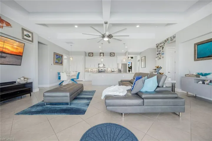 Living room with ceiling fan, recessed lighting, and beam ceiling