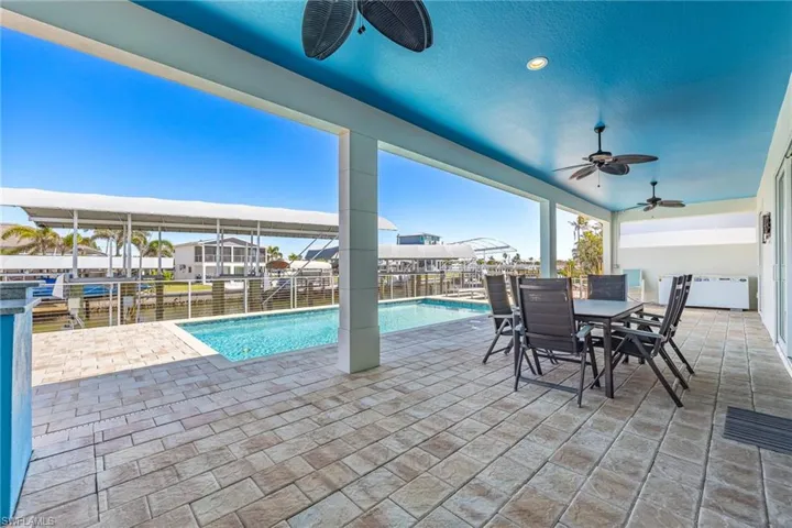 View of pool featuring a patio area, outdoor dining area, and a sunroom